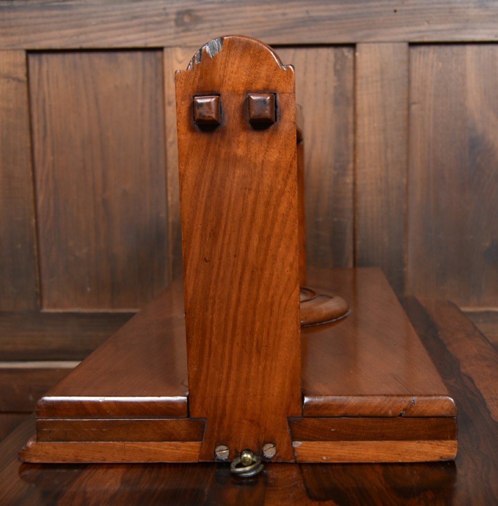 A Victorian mahogany tabletop book press featuring a wooden central screw thread, turned crossbar handles, and a polished base. View VII