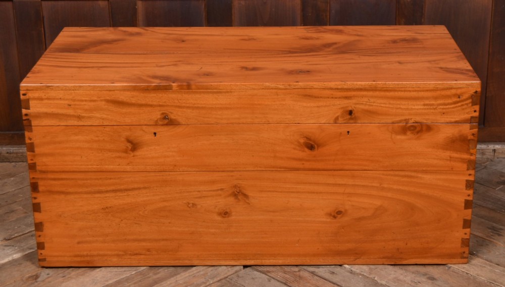 A rectangular warm amber camphor wood blanket box featuring exposed dovetail corner joints and metal side handles. View II
