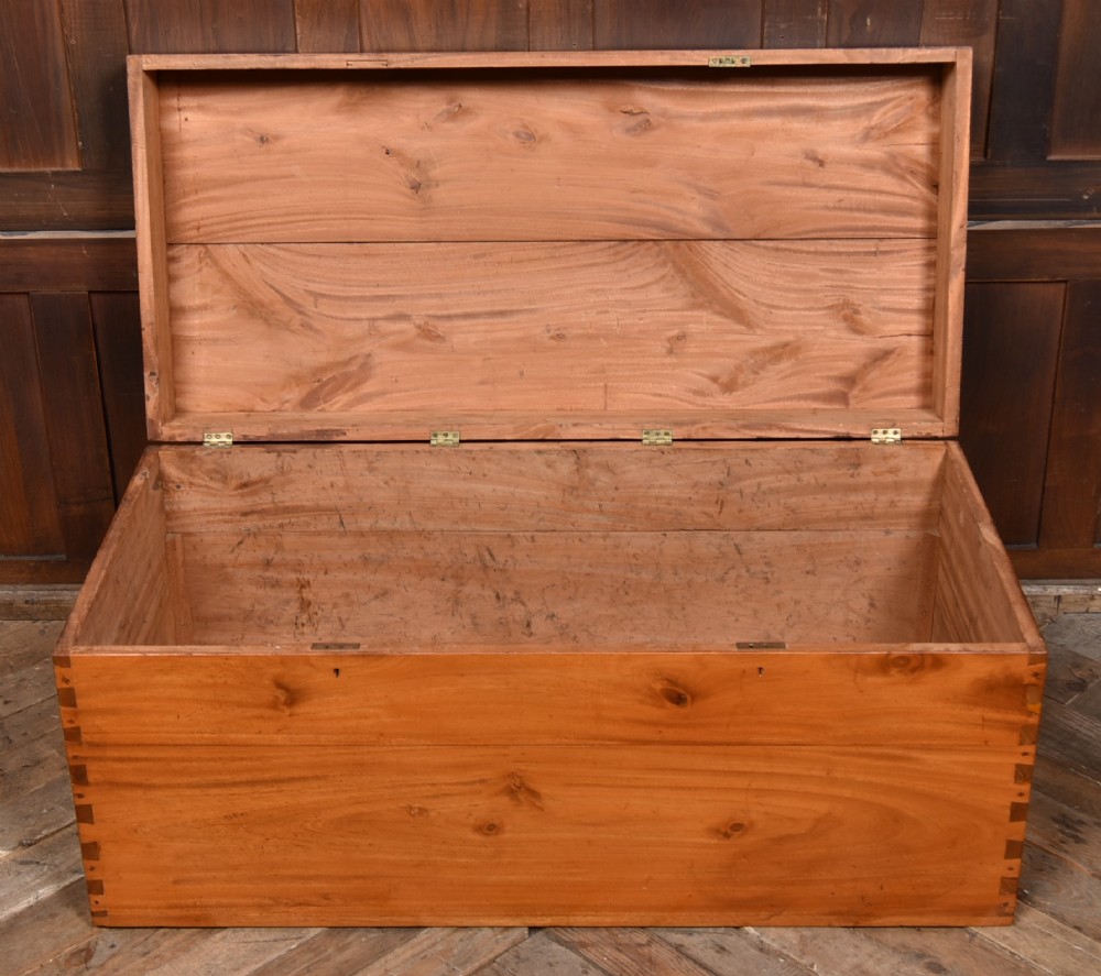 A rectangular warm amber camphor wood blanket box featuring exposed dovetail corner joints and metal side handles. View VI