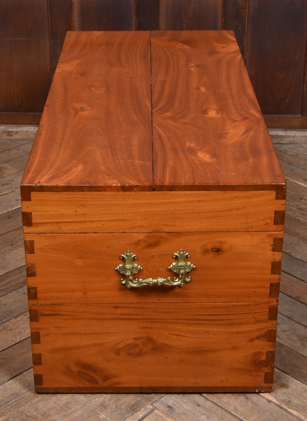 A rectangular warm amber camphor wood blanket box featuring exposed dovetail corner joints and metal side handles. View XI