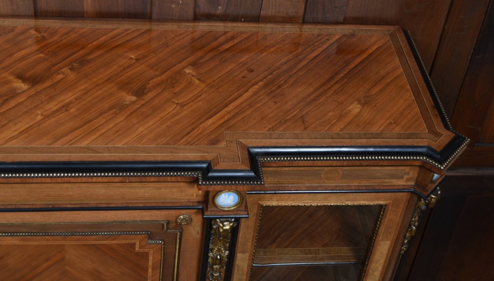 A Victorian inlaid rosewood credenza sideboard featuring central parquetry doors adorned with blue jasperware plaques, flanked by two glass-fronted side display cabinets. View X