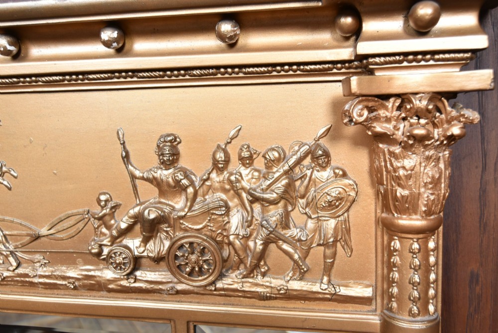 A Regency gilt overmantel mirror featuring a classical relief frieze above three bevelled mirror plates flanked by fluted Corinthian columns. View III
