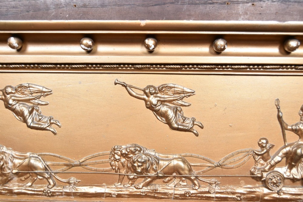A Regency gilt overmantel mirror featuring a classical relief frieze above three bevelled mirror plates flanked by fluted Corinthian columns. View IV