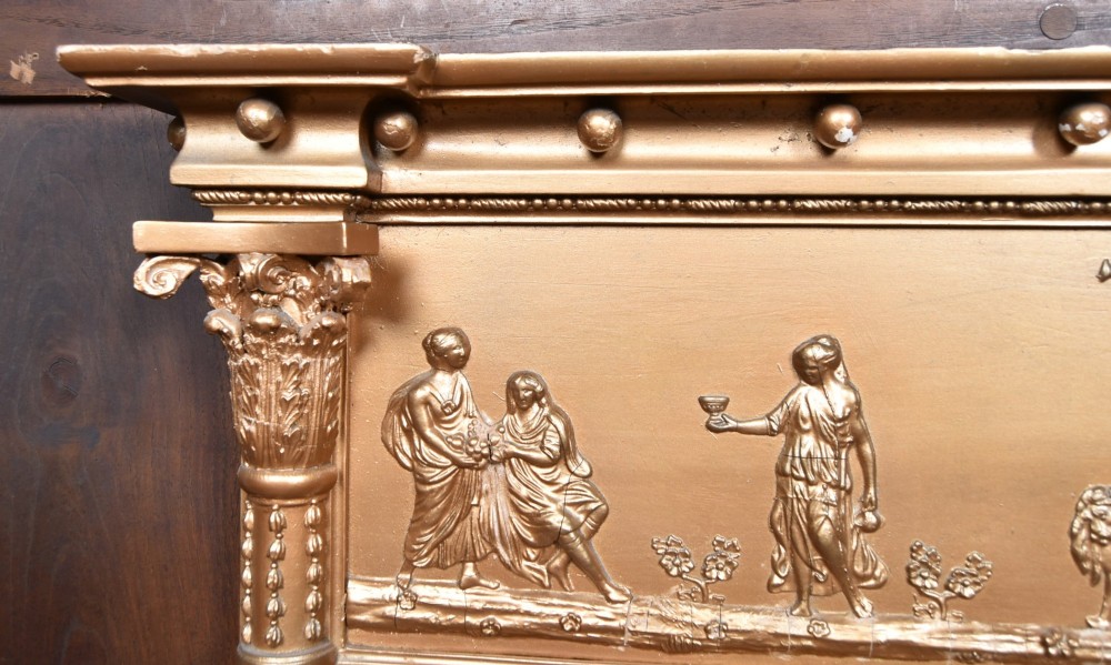 A Regency gilt overmantel mirror featuring a classical relief frieze above three bevelled mirror plates flanked by fluted Corinthian columns. View VI