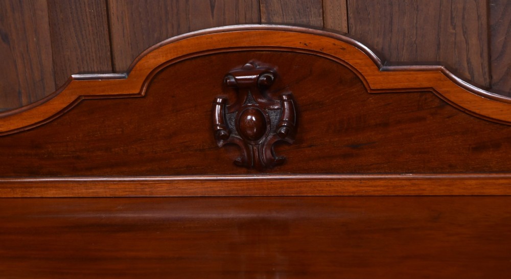 A Victorian mahogany three-tiered whatnot featuring turned column supports, two lower drawers with knob handles, an arched gallery top, and brass castors. View III