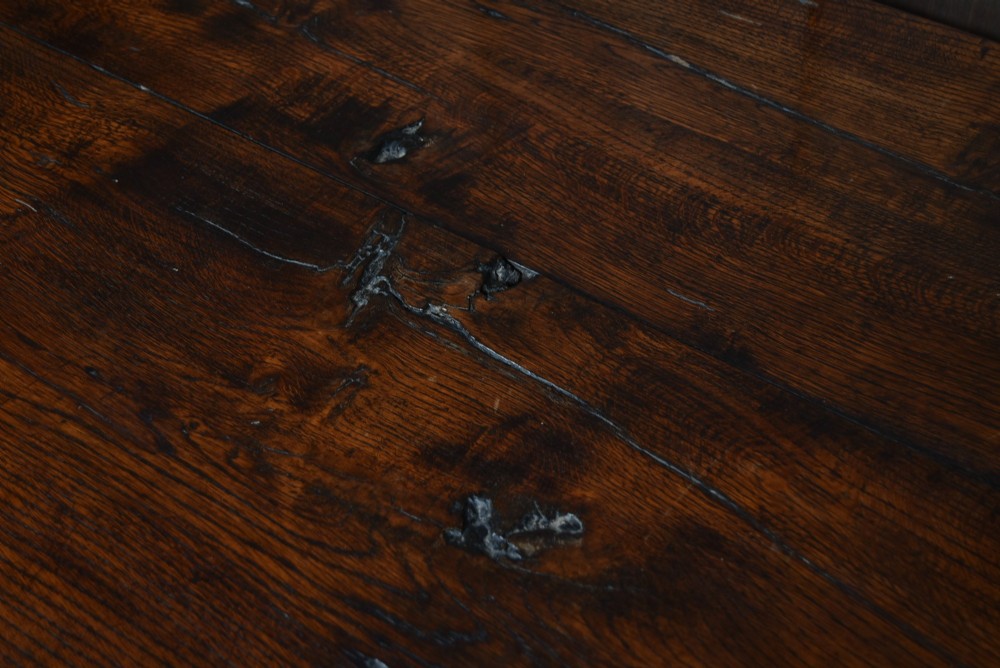 An 18th-century dark oak refectory dining table featuring a long plank top, scalloped apron carving, turned legs, and low foot stretchers. View X