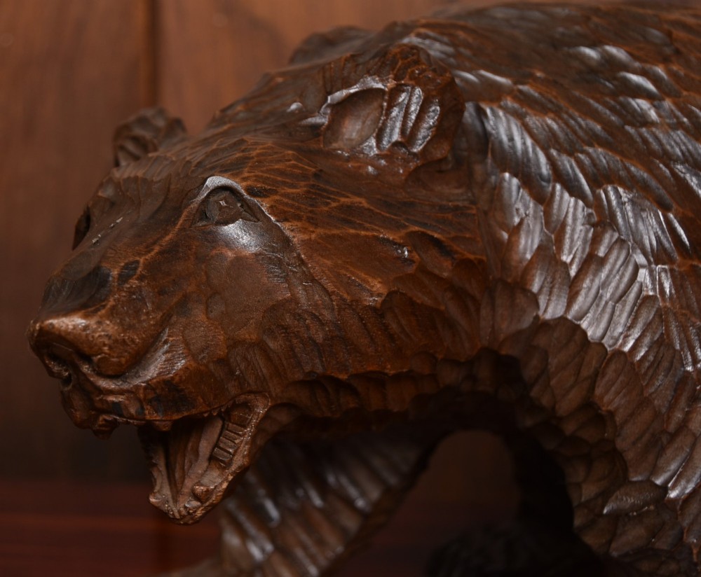 A hand-carved dark wood bear sculpture featuring detailed gouged fur texture and an open mouth. View II