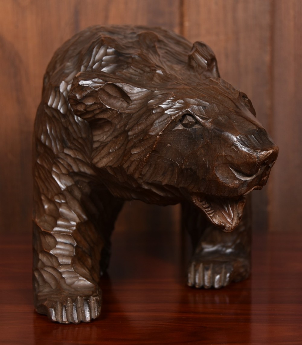 A hand-carved dark wood bear sculpture featuring detailed gouged fur texture and an open mouth. View III