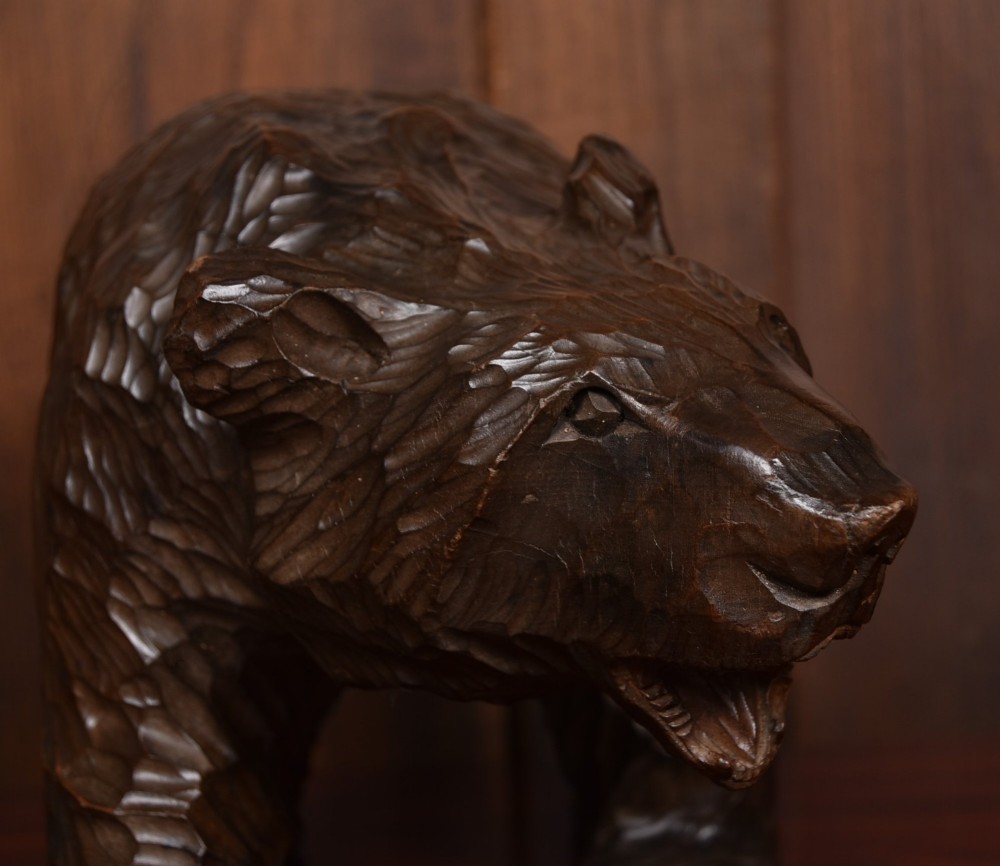 A hand-carved dark wood bear sculpture featuring detailed gouged fur texture and an open mouth. View IV