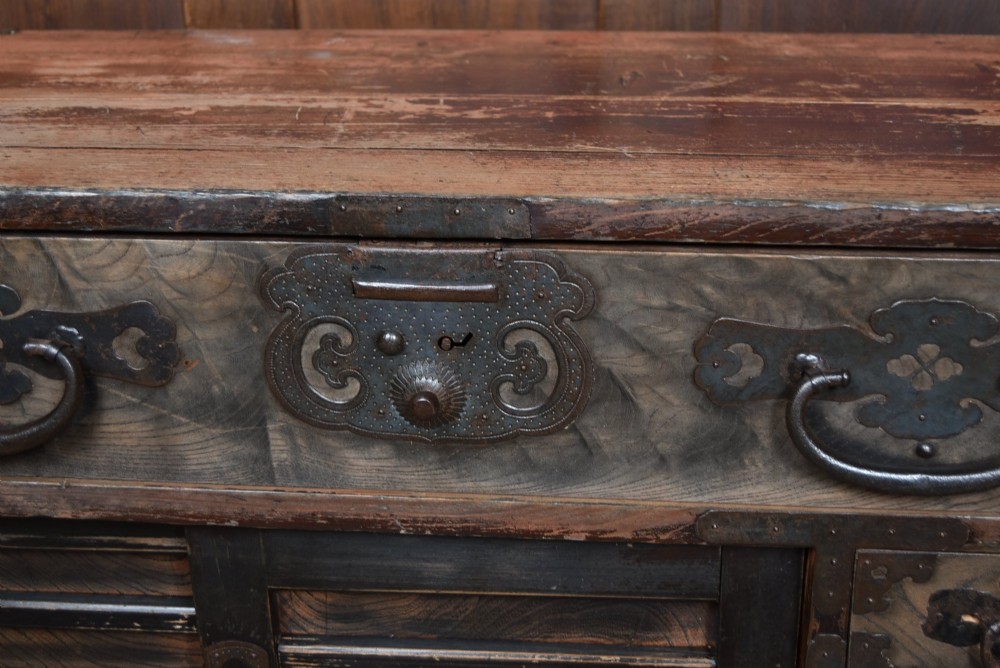 A Japanese tansu wooden chest featuring multiple drawers, sliding louvered doors, a small lockable door, and dark iron corner plates and drop handles. View IV