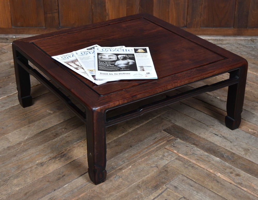 A low square Chinese padouk coffee table featuring a floating panel top, simple waist frame, and square legs terminating in horse-hoof feet.