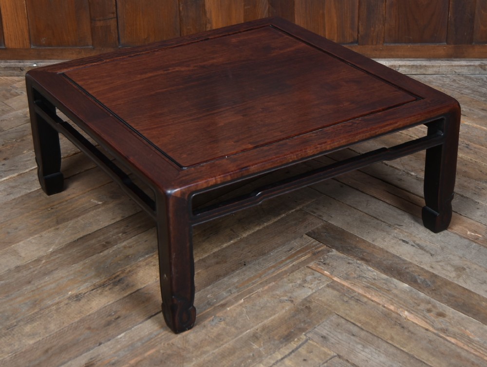 A low square Chinese padouk coffee table featuring a floating panel top, simple waist frame, and square legs terminating in horse-hoof feet. View II