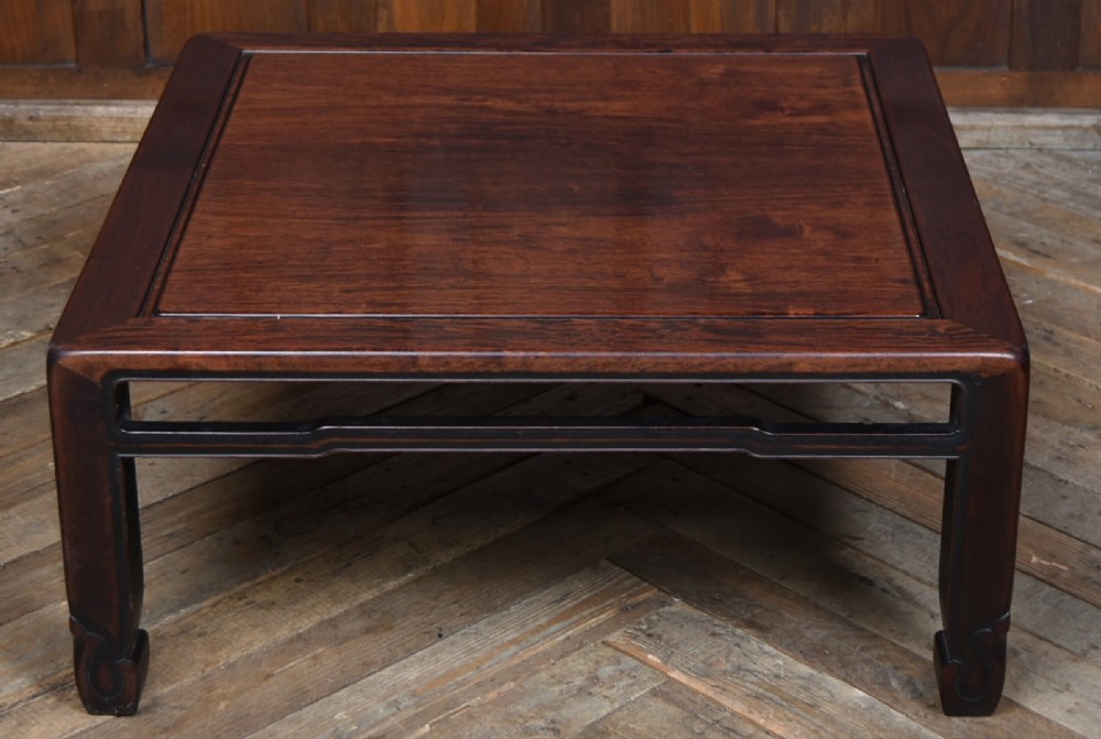 A low square Chinese padouk coffee table featuring a floating panel top, simple waist frame, and square legs terminating in horse-hoof feet. View III