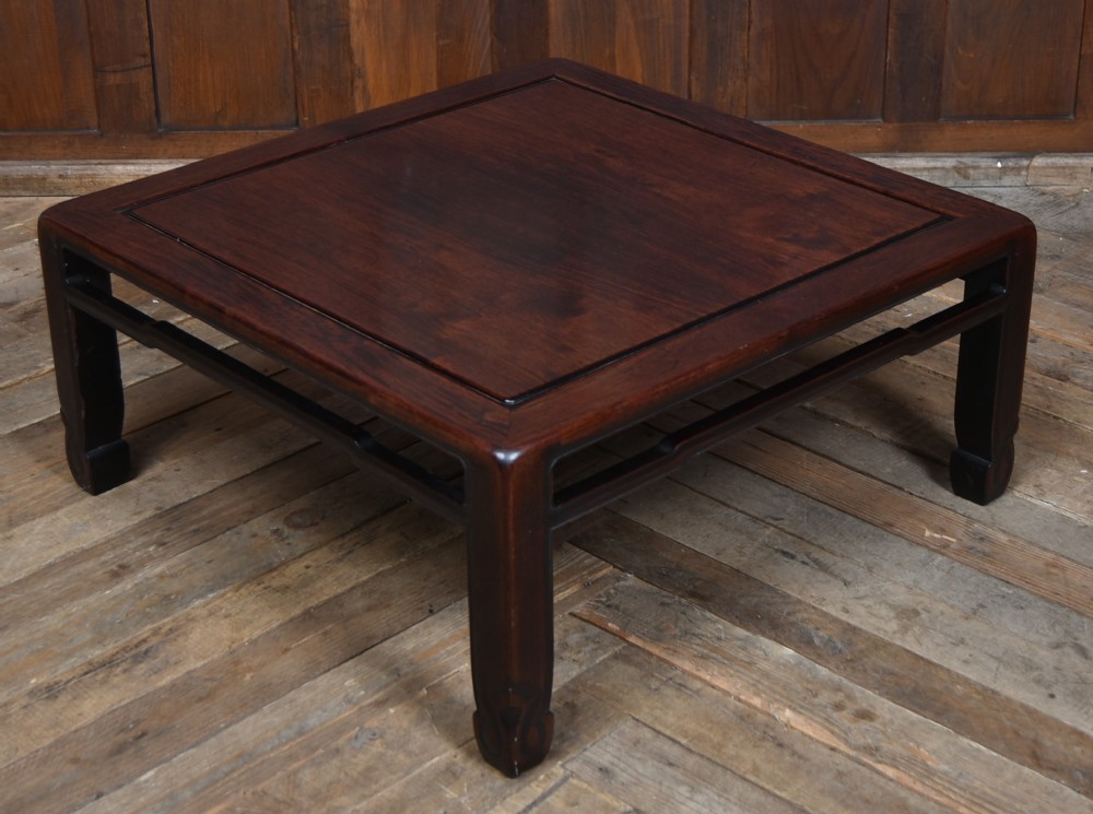 A low square Chinese padouk coffee table featuring a floating panel top, simple waist frame, and square legs terminating in horse-hoof feet. View IV