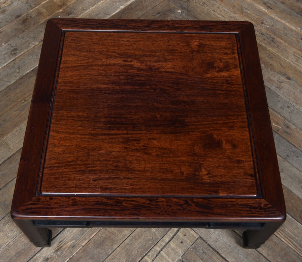 A low square Chinese padouk coffee table featuring a floating panel top, simple waist frame, and square legs terminating in horse-hoof feet. View V