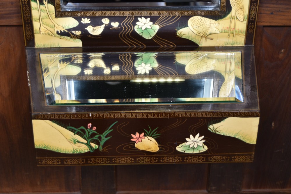 A tall black lacquered rectangular wall mirror featuring an integrated bottom shelf and painted borders with cranes, lotus blossoms, and botanical details. View VI