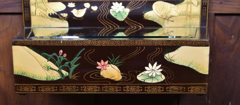 A tall black lacquered rectangular wall mirror featuring an integrated bottom shelf and painted borders with cranes, lotus blossoms, and botanical details. View VIII