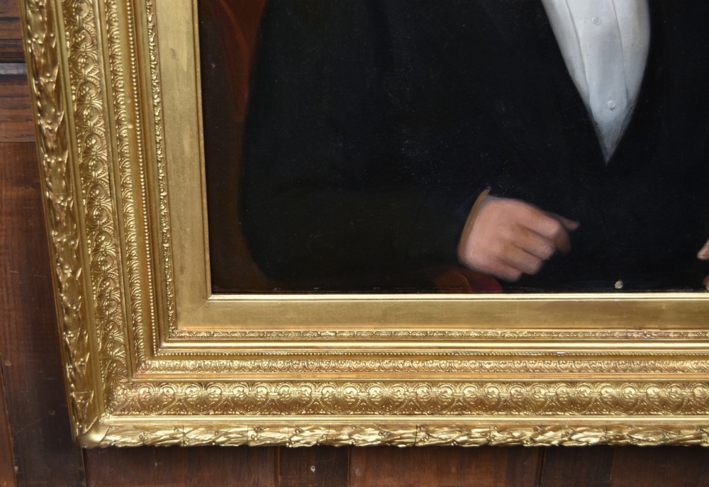 A nineteenth-century oil painting on canvas depicting a seated gentleman wearing a black jacket and white shirt, housed within a gilded wooden frame. View IV