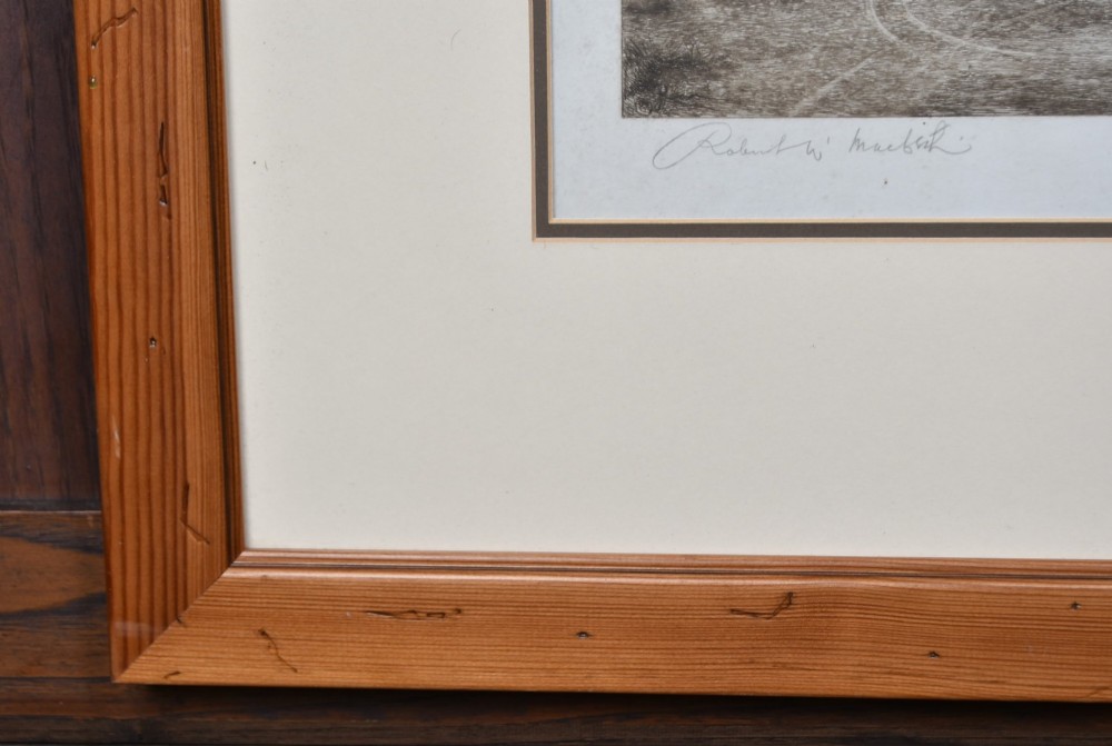 A framed 19th-century monochrome etching depicting figures, a horse, and a dog beside a river outside a village inn, encased in a light wood frame with an off-white mount. View XII