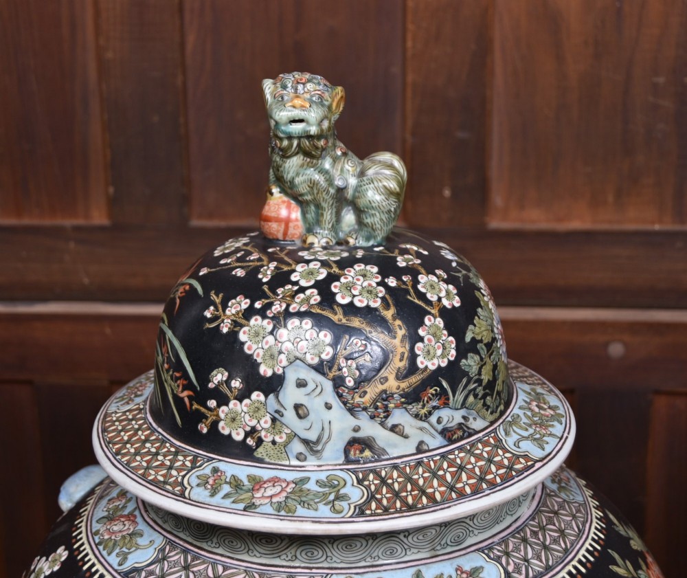 A pair of large black-ground Chinese porcelain floor jars with domed lids topped with foo dog finials and painted peacock, floral, and rockery motifs. View XIV