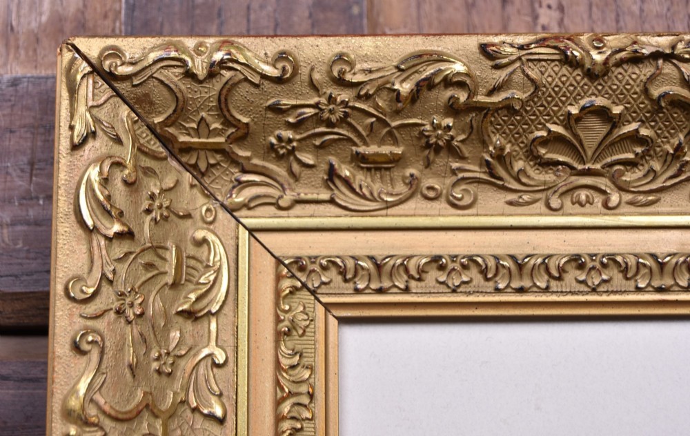 A framed monochrome print depicting a young violinist in period costume, set within a cream mount and an ornate gilded frame. View V