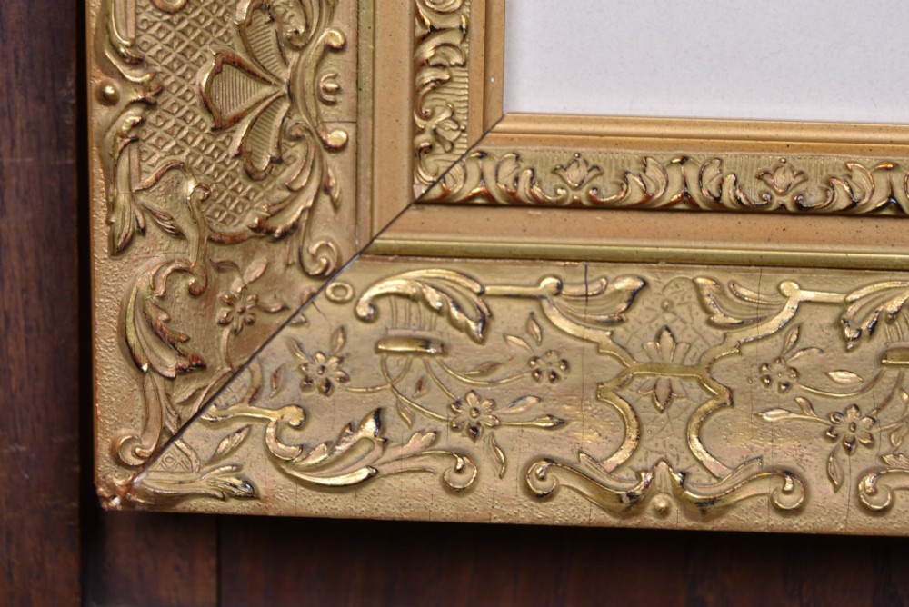 A framed monochrome print depicting a young violinist in period costume, set within a cream mount and an ornate gilded frame. View VII