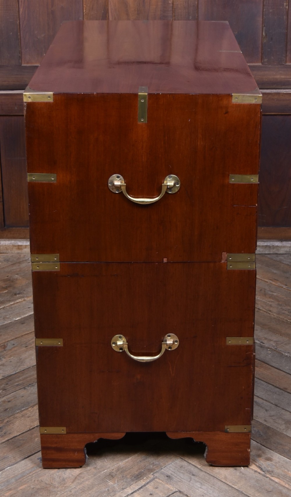 A 19th-century mahogany campaign chest of drawers featuring flush brass handles, corner brackets, and a two-section design. View VI