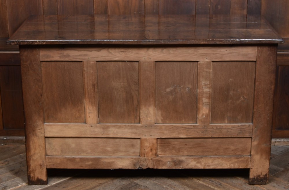 An 18th-century dark oak coffer featuring three carved panels, geometric marquetry inlay, and two lower drawers. View XII