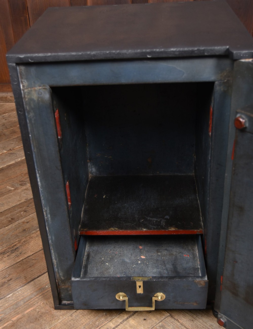 A heavy black painted iron safe featuring a rectangular body, a brass maker plaque for James Bruce of Glasgow, a faceted brass handle, and a brass fire-resisting emblem. View IX