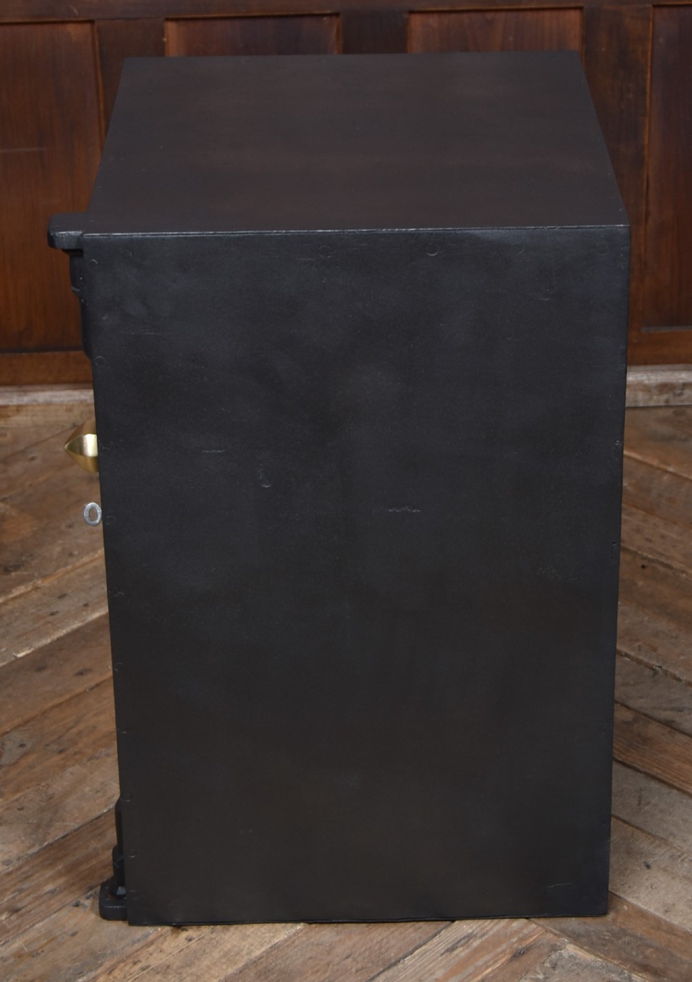 A heavy black painted iron safe featuring a rectangular body, a brass maker plaque for James Bruce of Glasgow, a faceted brass handle, and a brass fire-resisting emblem. View XIII