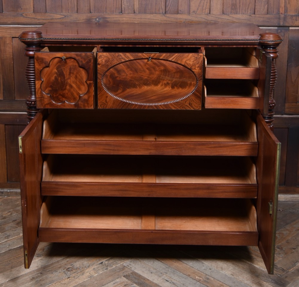 A Victorian mahogany secretaire cabinet featuring Gothic arch decorative panels, turned columns on either side, and flame mahogany veneers. View IV