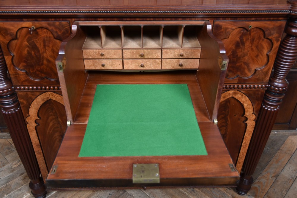 A Victorian mahogany secretaire cabinet featuring Gothic arch decorative panels, turned columns on either side, and flame mahogany veneers. View VII