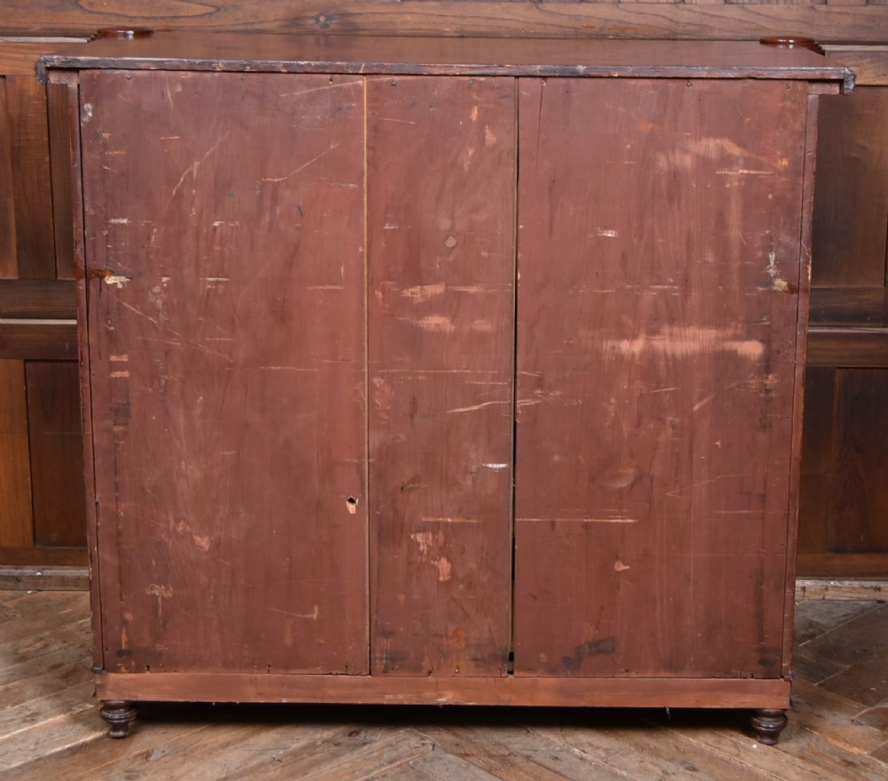 A Victorian mahogany secretaire cabinet featuring Gothic arch decorative panels, turned columns on either side, and flame mahogany veneers. View X