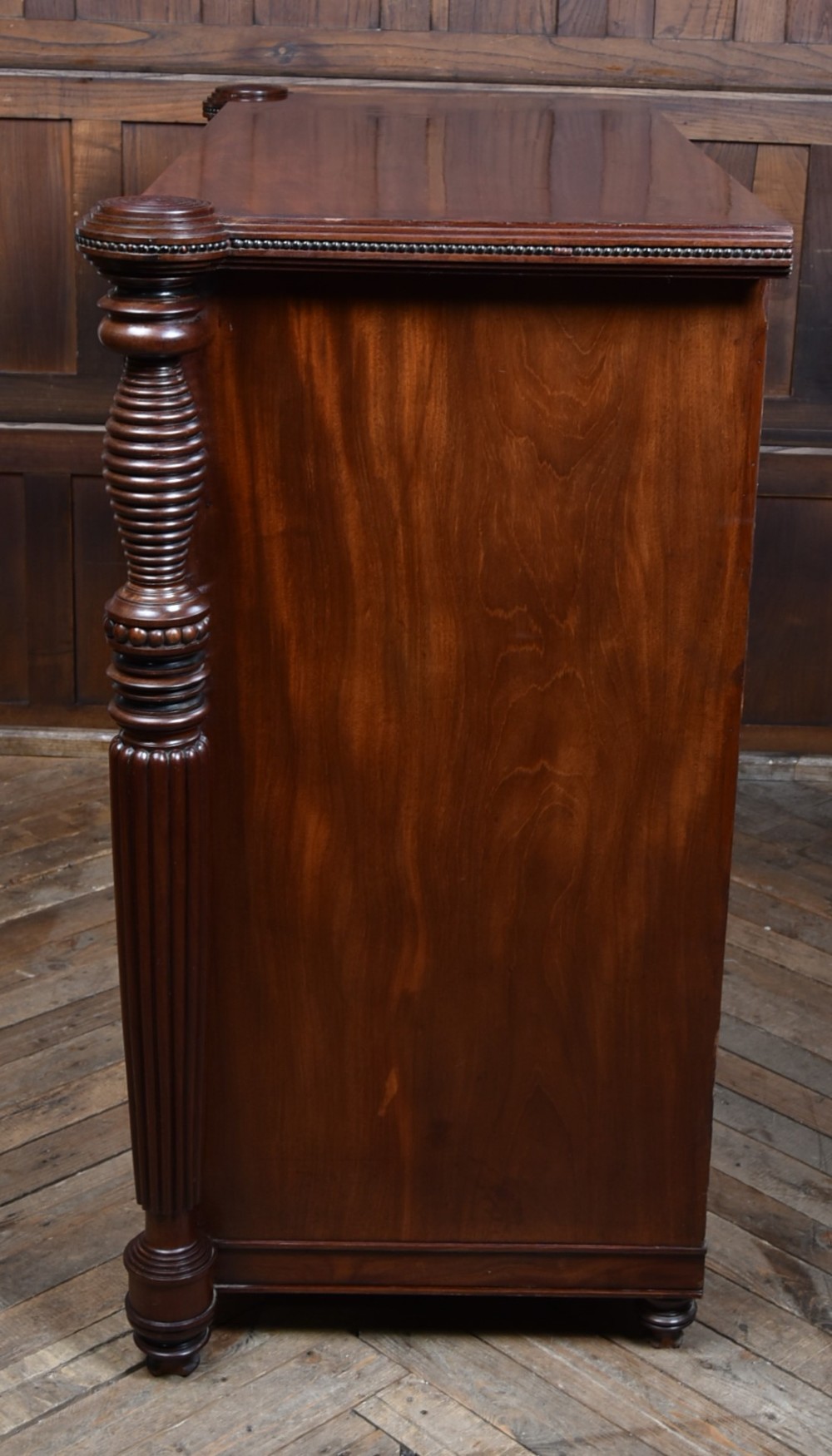 A Victorian mahogany secretaire cabinet featuring Gothic arch decorative panels, turned columns on either side, and flame mahogany veneers. View XI