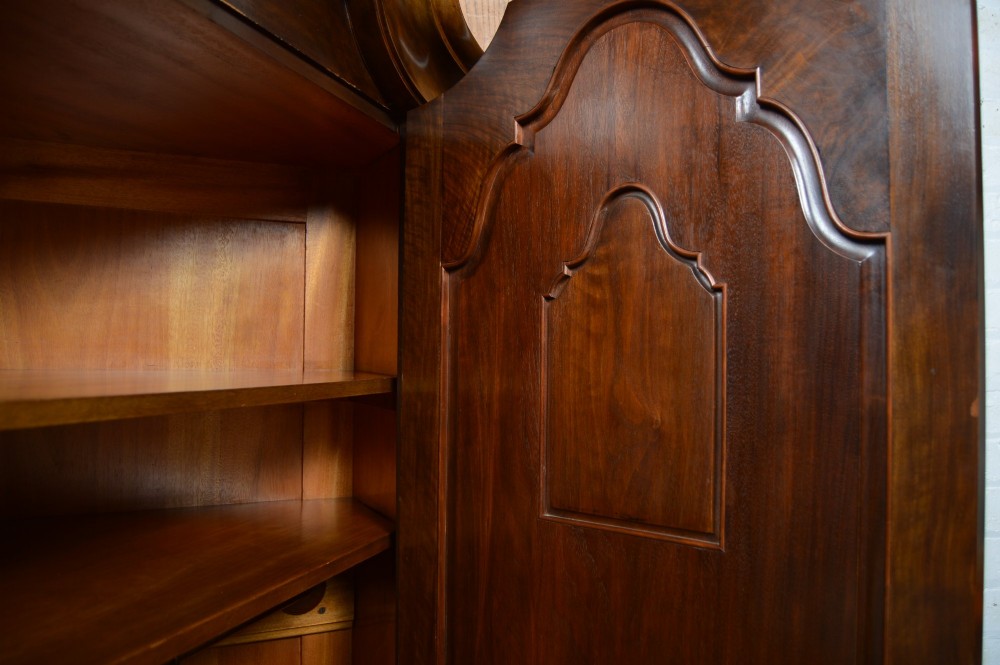 An antique Art Nouveau corner wardrobe crafted from warm walnut wood with an arched pediment, a single panel door featuring floral marquetry, and a shaped plinth base. View XIV