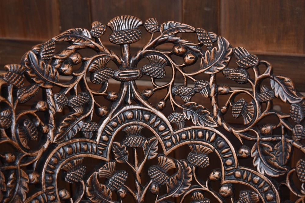 A nineteenth-century dark carved oak armchair featuring intricate openwork thistle motifs across the high arched back and sides, fitted with a floral needlepoint seat cushion. View IV