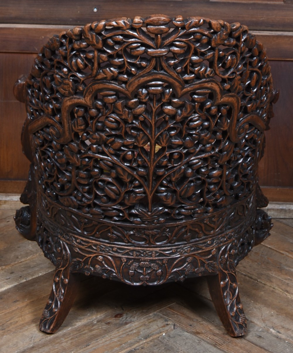 A nineteenth-century dark carved oak armchair featuring intricate openwork thistle motifs across the high arched back and sides, fitted with a floral needlepoint seat cushion. View X