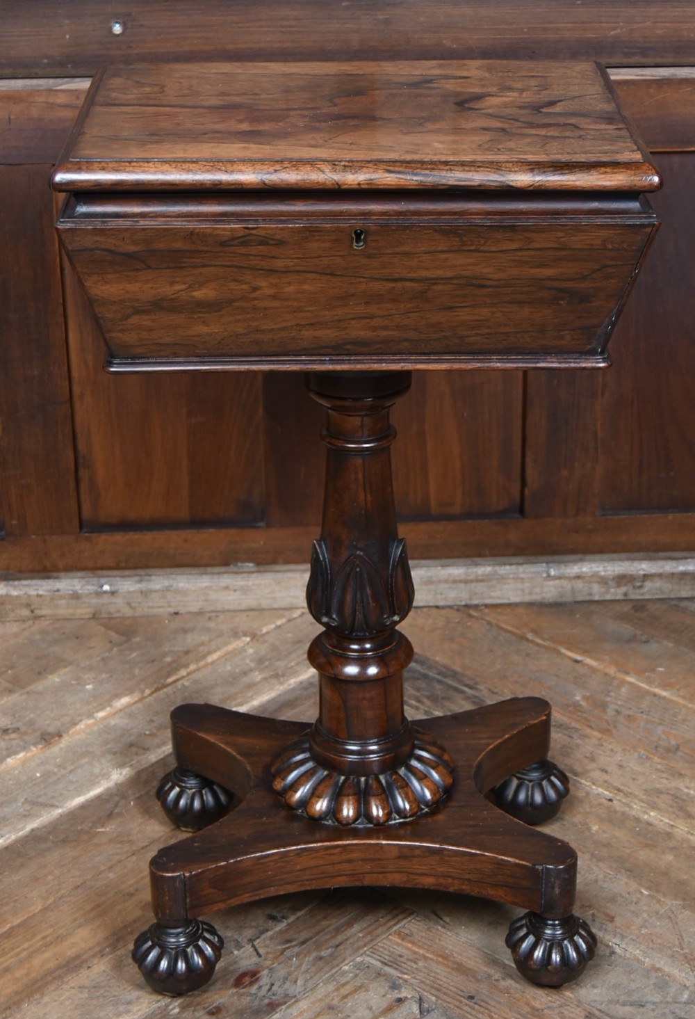 A Victorian dark rosewood teapoy featuring a sarcophagus-shaped chest top resting on a turned carved pedestal and quadruped base. View II