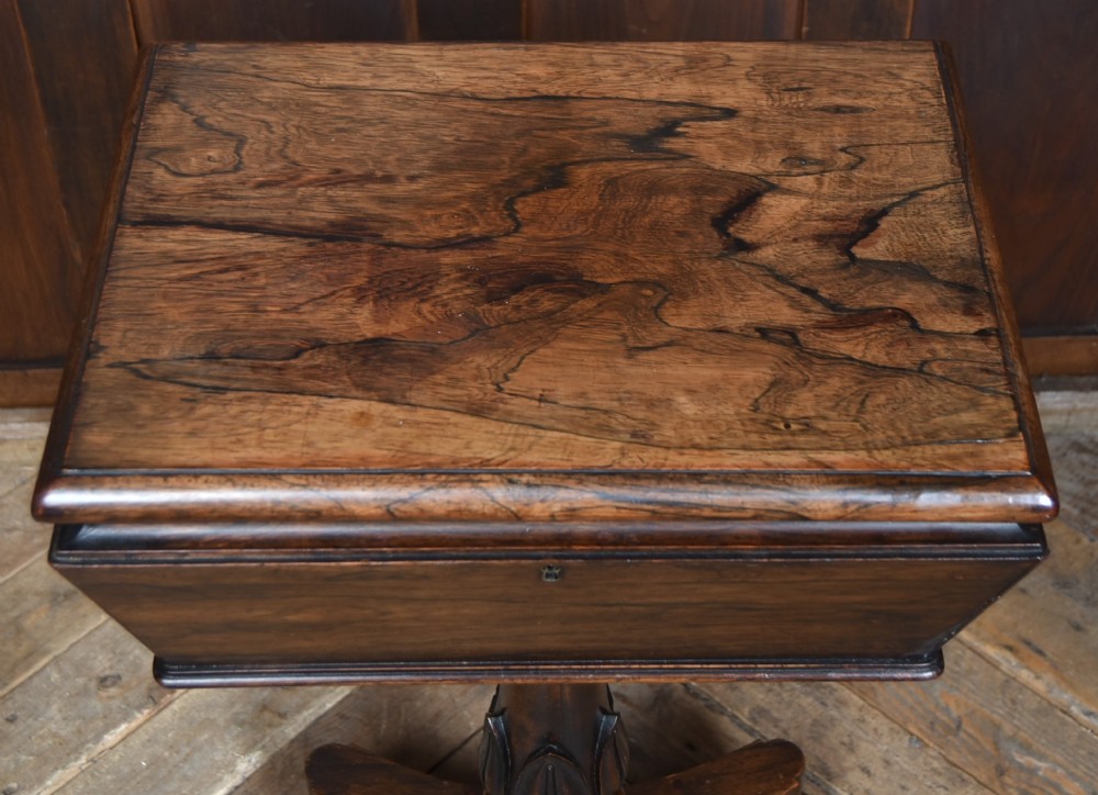 A Victorian dark rosewood teapoy featuring a sarcophagus-shaped chest top resting on a turned carved pedestal and quadruped base. View III