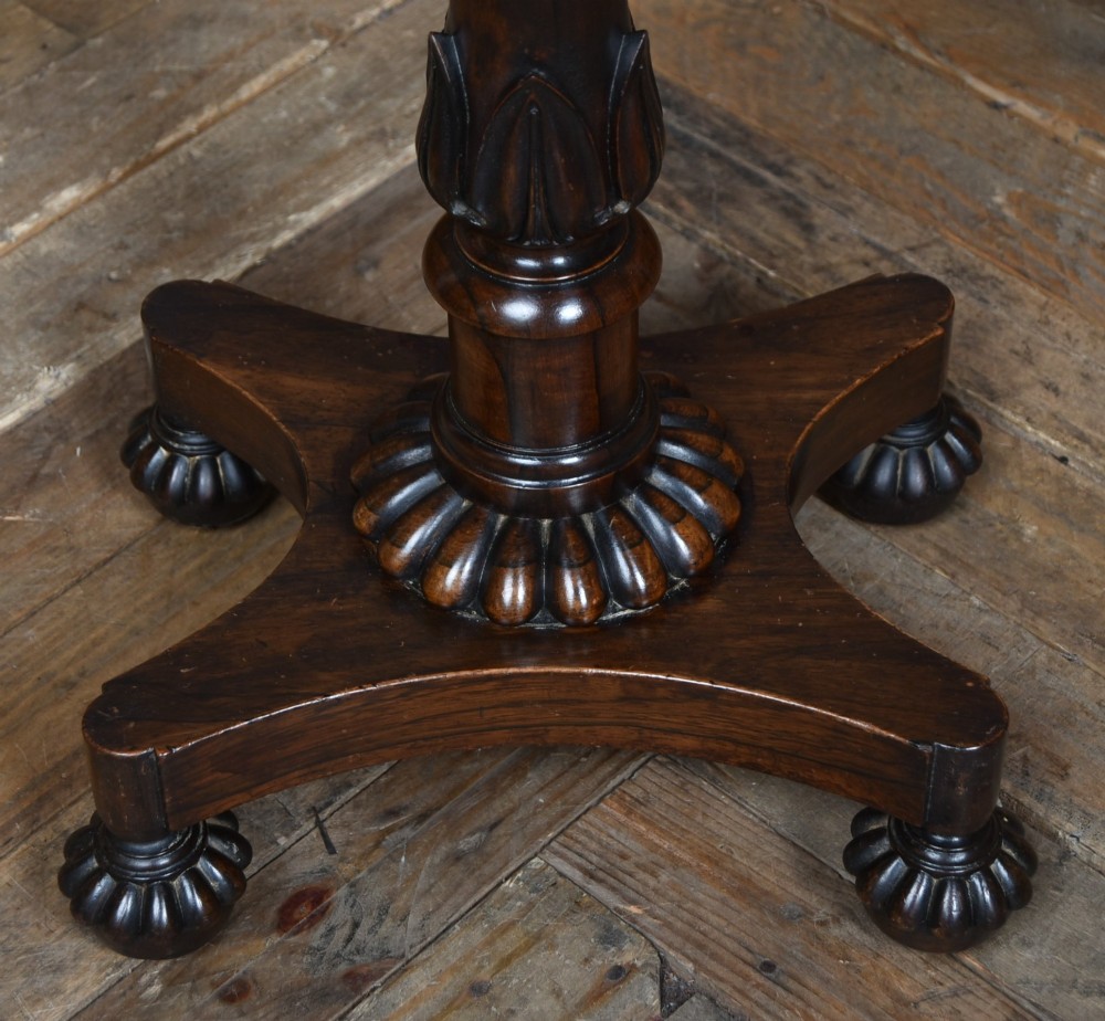 A Victorian dark rosewood teapoy featuring a sarcophagus-shaped chest top resting on a turned carved pedestal and quadruped base. View IV
