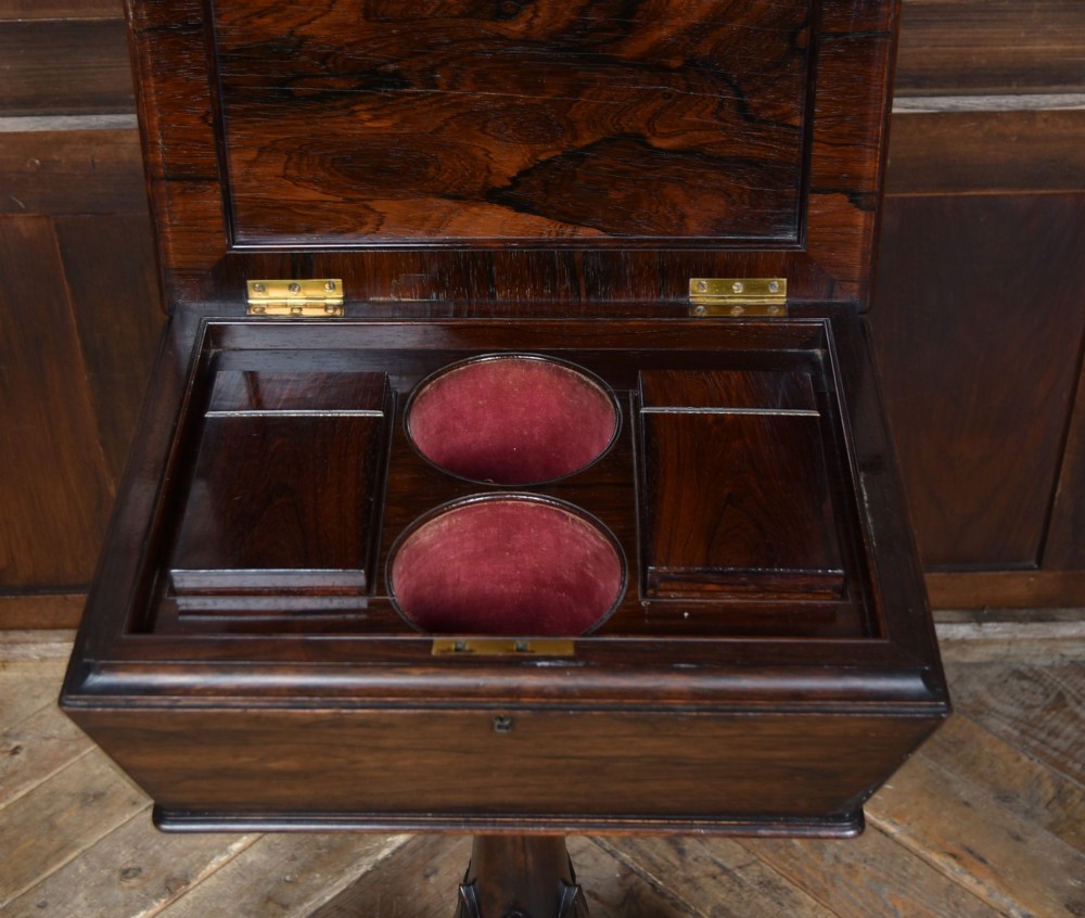 A Victorian dark rosewood teapoy featuring a sarcophagus-shaped chest top resting on a turned carved pedestal and quadruped base. View VI