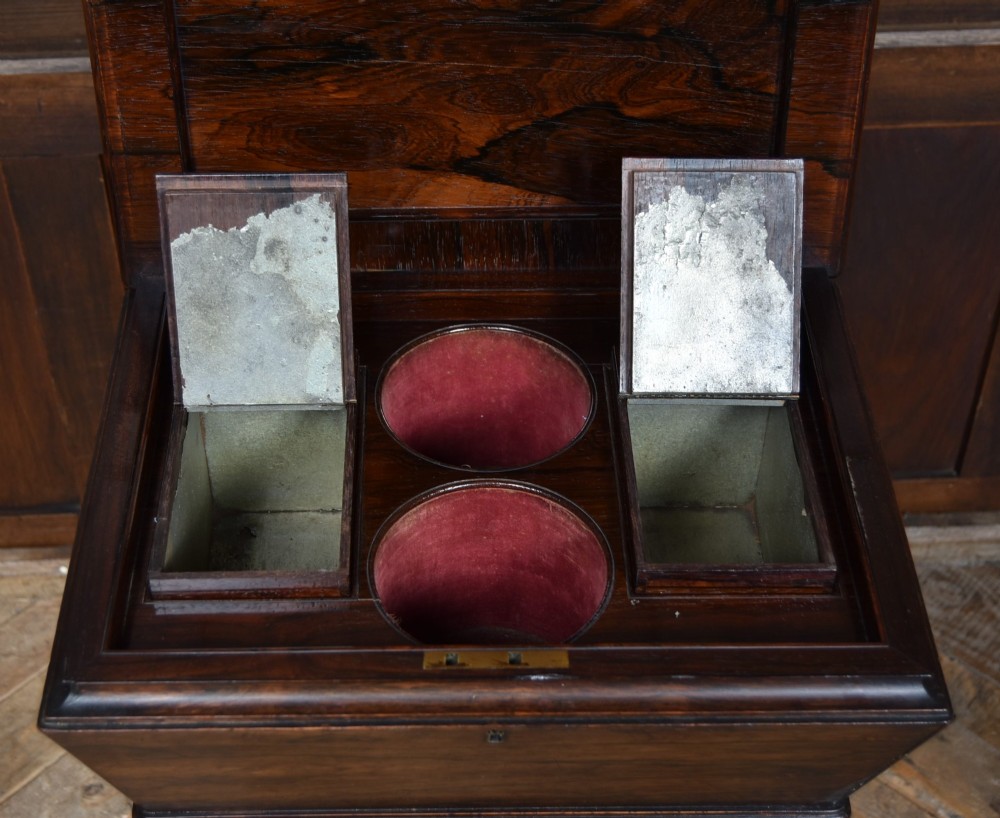 A Victorian dark rosewood teapoy featuring a sarcophagus-shaped chest top resting on a turned carved pedestal and quadruped base. View VII