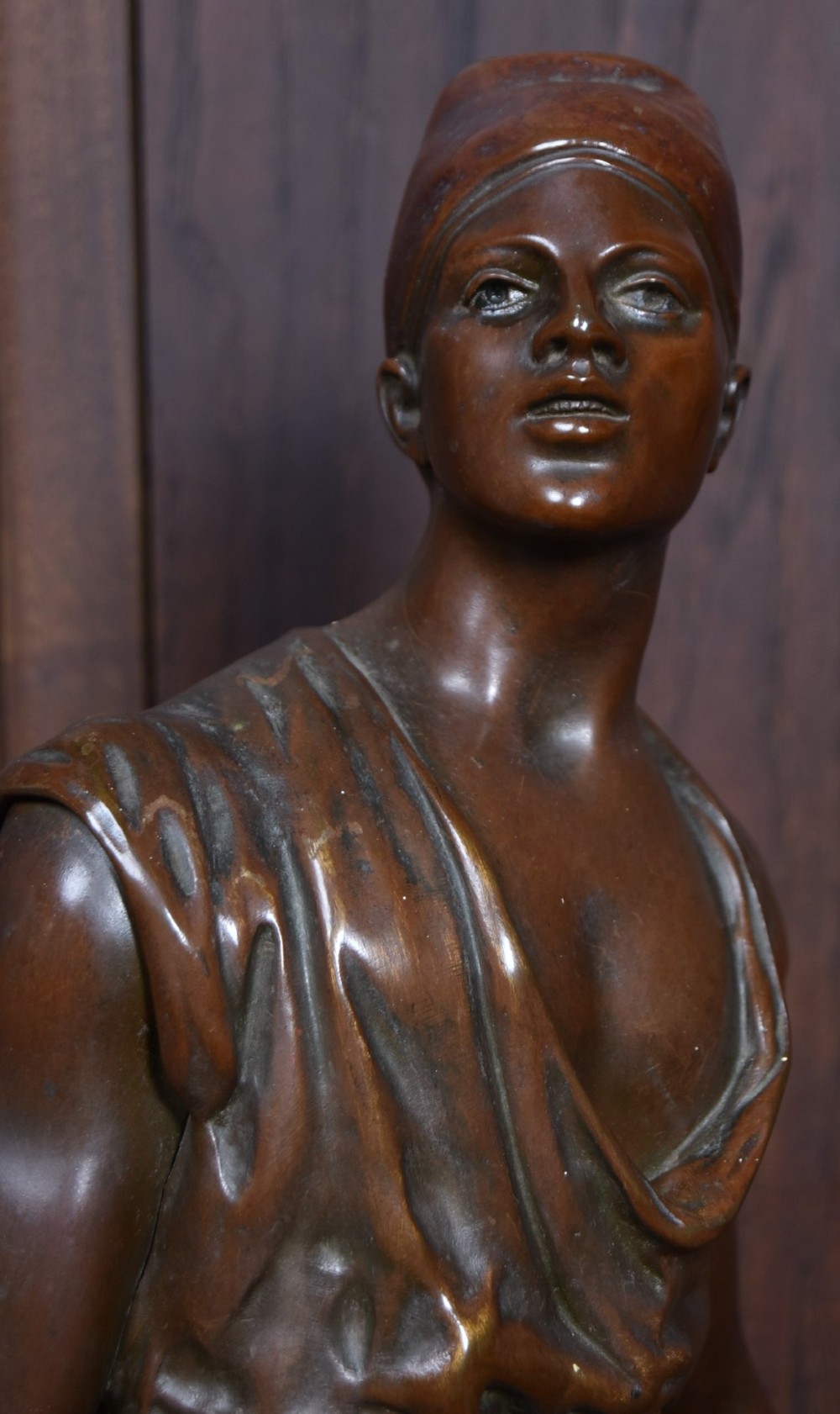 A dark brown patinated bronze sculpture depicting a standing Tunisian water bearer carrying two vessels on a rectangular moulded base. View II