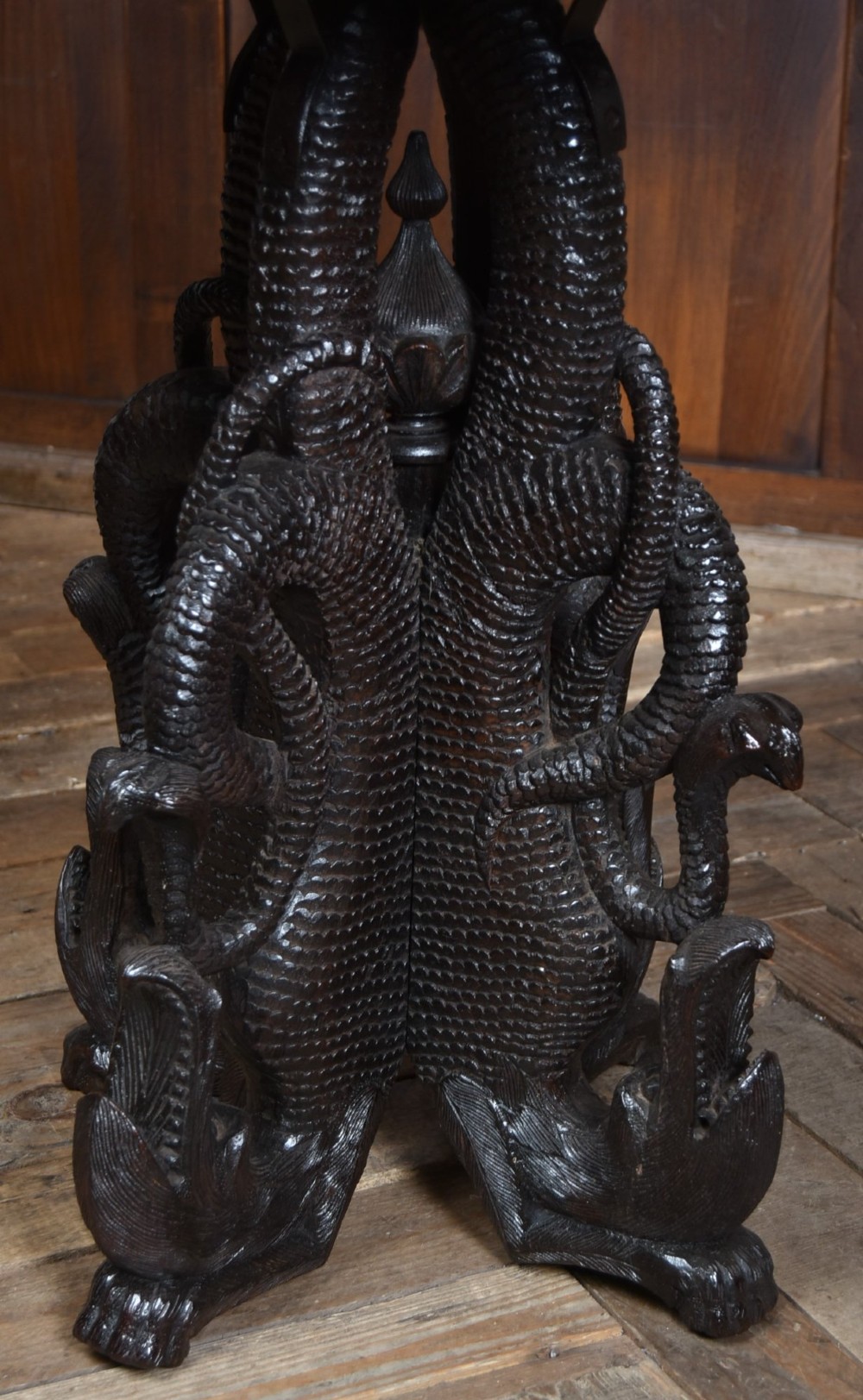 A 19th-century circular Burmese table in dark carved wood with a detailed openwork apron and a sculpted serpent base. View VI