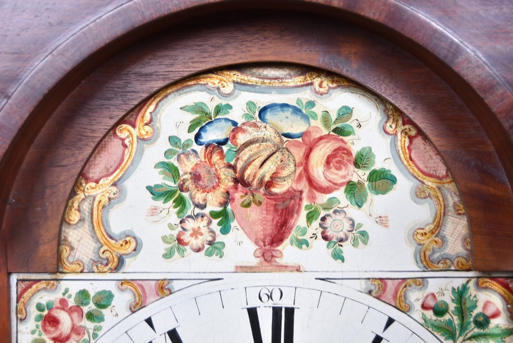A Scottish mahogany longcase clock featuring a swan-neck pediment with brass finials, a hand-painted dial face, and flame mahogany veneers. View VII