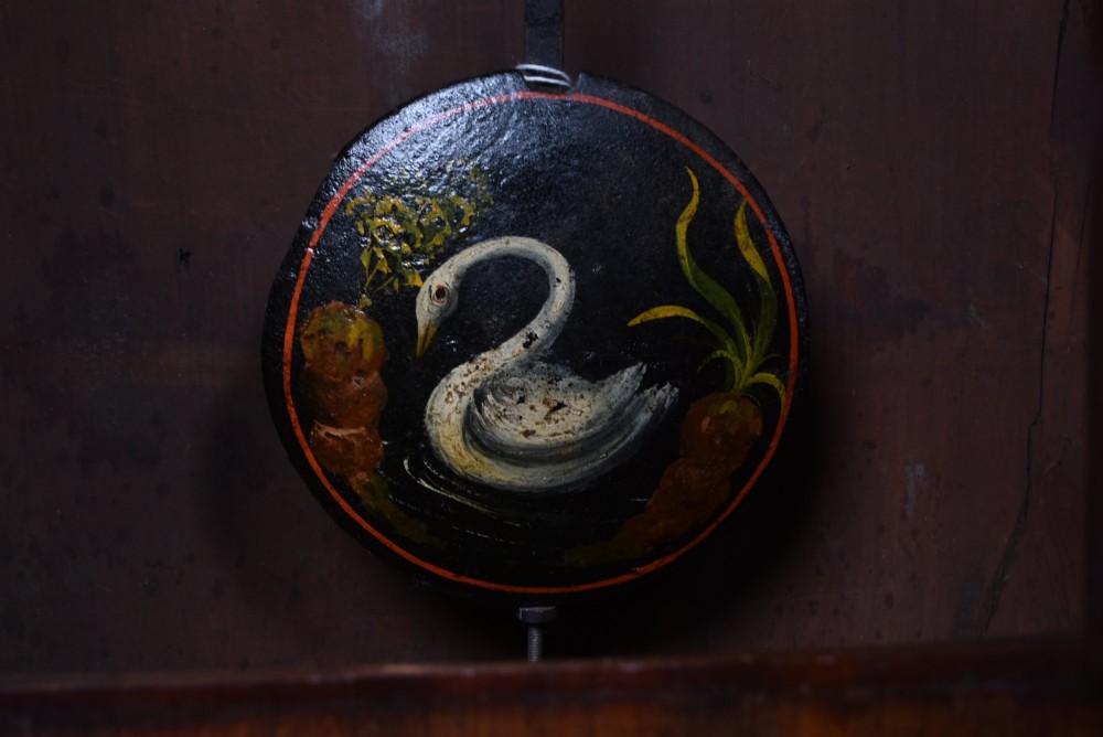 A Scottish mahogany longcase clock featuring a swan-neck pediment with brass finials, a hand-painted dial face, and flame mahogany veneers. View IX