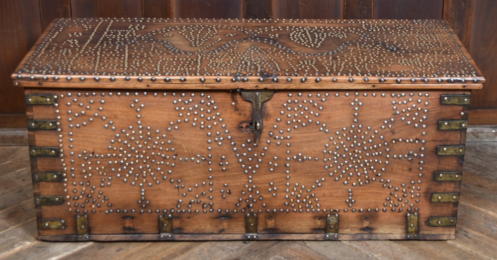 A solid padouk wood rectangular blanket box featuring intricate geometric brass stud patterns and metal strap reinforcements. View II