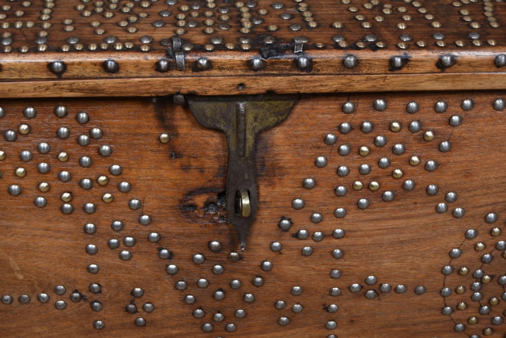 A solid padouk wood rectangular blanket box featuring intricate geometric brass stud patterns and metal strap reinforcements. View VI