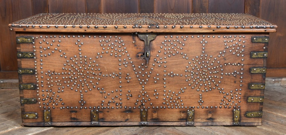 A solid padouk wood rectangular blanket box featuring intricate geometric brass stud patterns and metal strap reinforcements. View VII