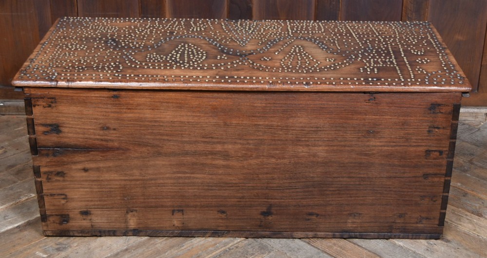 A solid padouk wood rectangular blanket box featuring intricate geometric brass stud patterns and metal strap reinforcements. View XIII